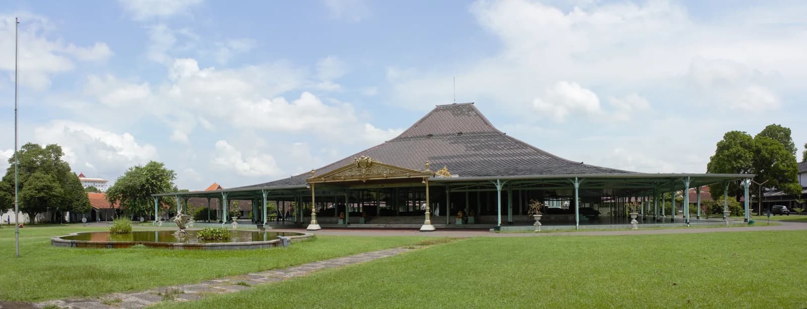 The broad pendopo pavilion at Mangkunegaran Palace with a lawn and fountain