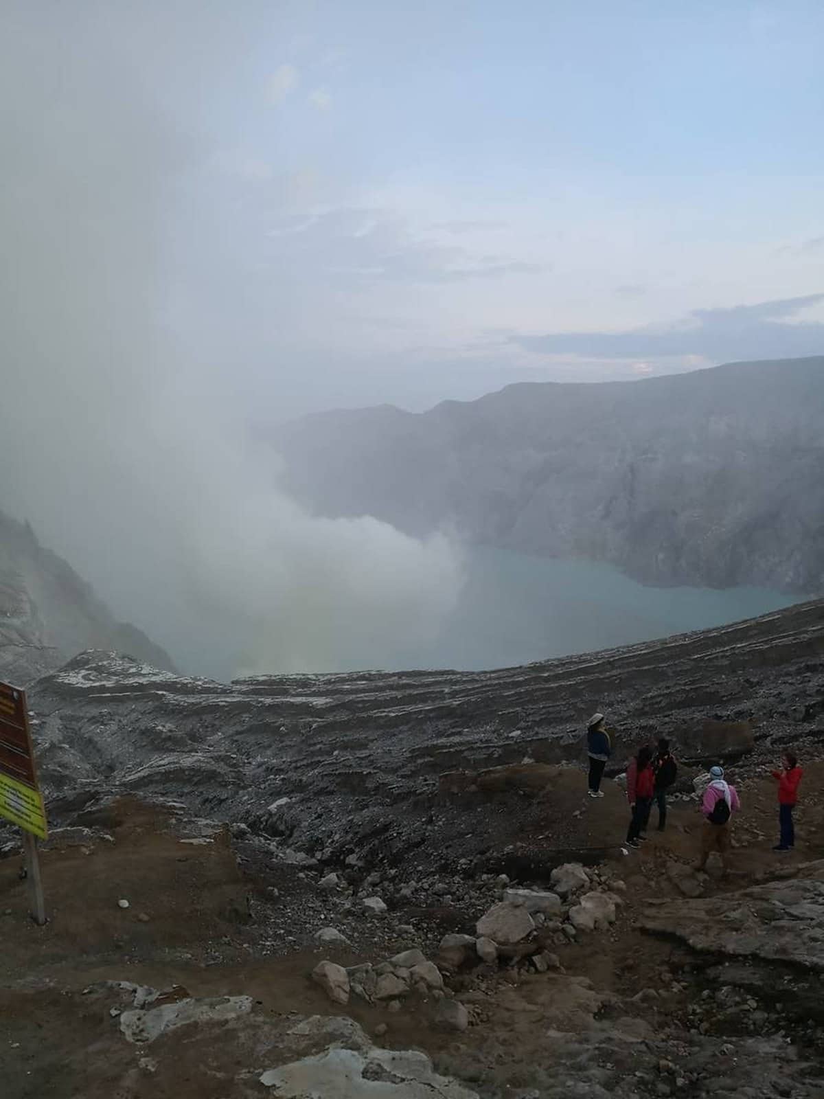 Górnicy siarki z koszami przy kraterze Kawah Ijen przed świtem