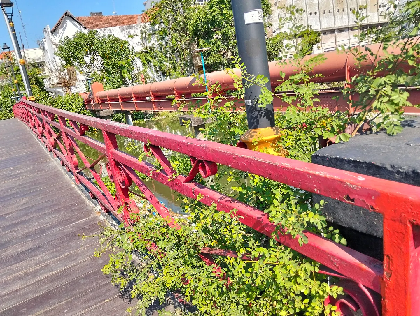 Czerwone balustrady mostu Jembatan Merah, kanał i zabudowa Kota Lama